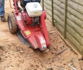 Red stump remover with stump ground down to saw dust